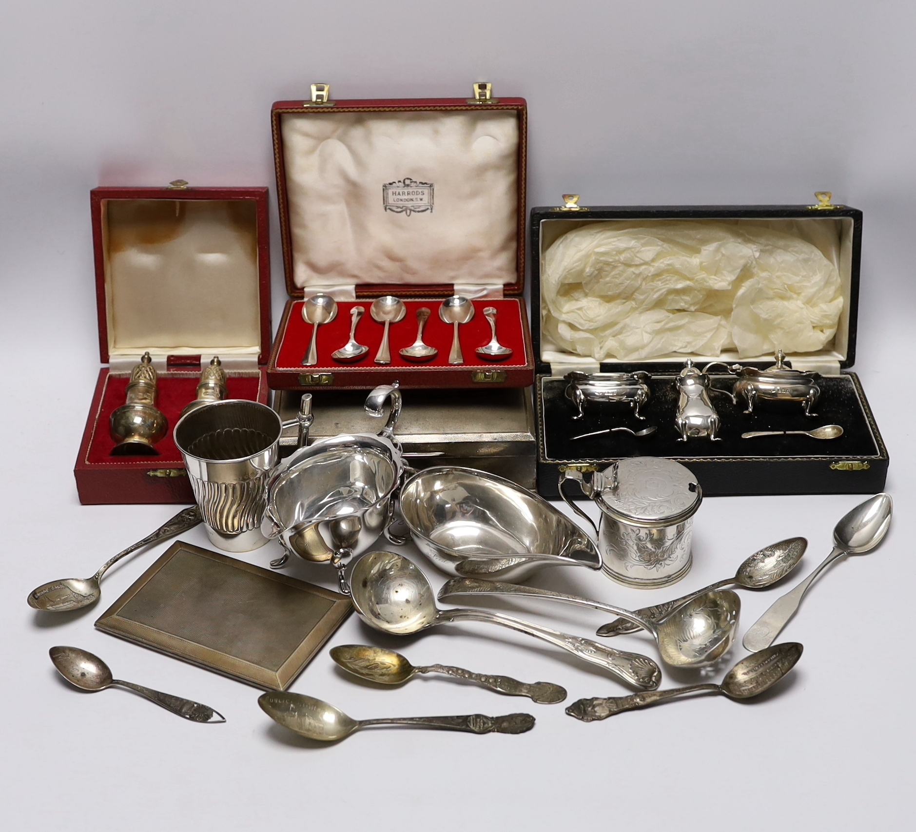 Sundry silver wares including a cigarette box and case, cased condiment set, cased pair of pepperettes and cased set of six teaspoons, sauceboat, Victorian mustard, Victorian mug with angular handle, nine items of flatwa